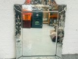 un miroir accroché au mur à côté d'une chaise