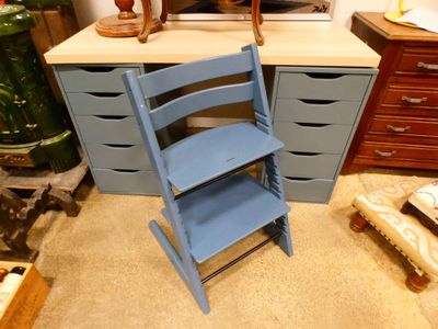 a blue chair sitting in front of a desk in a room