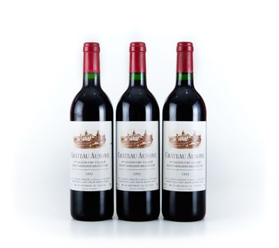trois bouteilles de vin rouge posées l'une à côté de l'autre sur une surface blanche