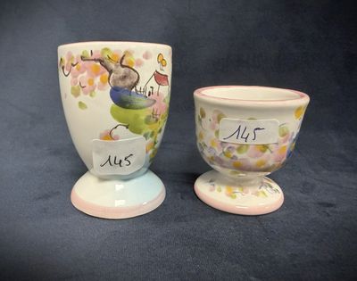 two egg cups that have been painted with words on them