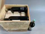 two bottles of wine in a wooden box on a table