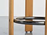 a close up of a wooden stool with a metal ring on top of it