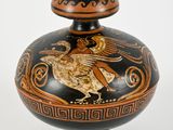 a black and gold vase with a bird on it