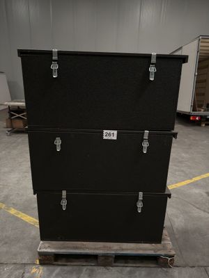 three black boxes stacked on top of each other in a warehouse