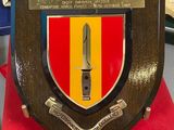 a plaque with a knife on top of it on a table