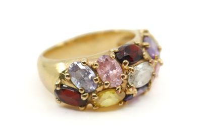 gros plan d'une bague en or avec des pierres multicolores