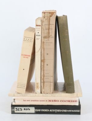 plusieurs livres sont empilés sur une surface blanche