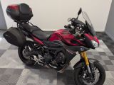 a red and black motorcycle parked on a checkered floor