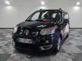 La petite camionnette noire est garée sur un sol en carrelage à damier.