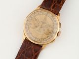 gros plan d'une montre sur une surface blanche avec un bracelet marron