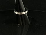 a close up of a silver ring on a black surface