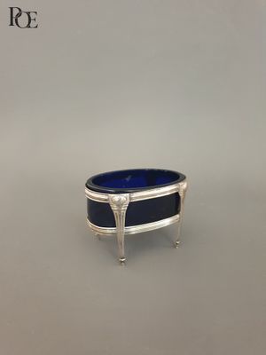 un bol argenté et bleu posé sur un socle en argent