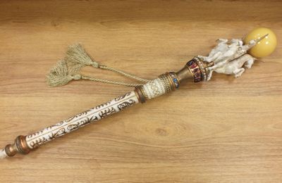 un petit bâtonnet en bois surmonté d'une perle en or