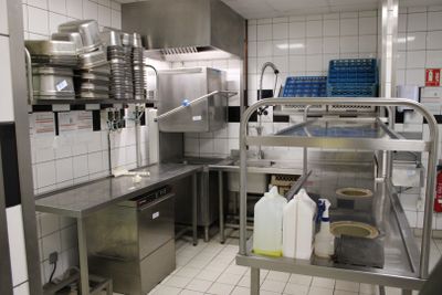 une cuisine avec de nombreux plans de travail en inox