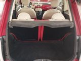 the back of a red car with its trunk open and the seats folded down
