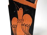 a black and orange vase with a bird on it