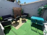 une terrasse avec une table et des chaises