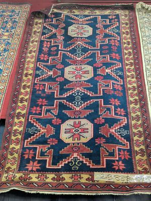 three rugs are laid out on a wooden floor in a room