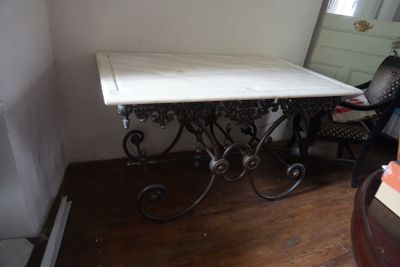 une table au plateau en marbre, dans un coin de la pièce