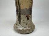 a vase that has a picture of a person walking in the snow