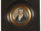 portrait d'un homme en costume noir et chemise blanche, dans un cadre doré
