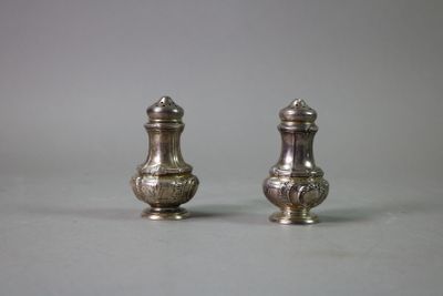 pair of silver salt and pepper shakers on grey background