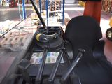 a black seat on the back of a yellow tractor