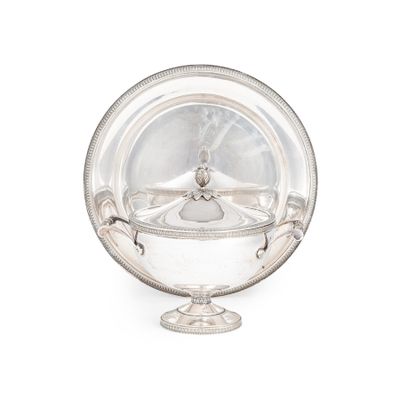 un plat ancien en argent avec un couvercle en verre, posé sur un socle