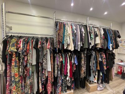 un portemanteau dans un magasin de vêtements, sur lequel sont suspendus des vêtements