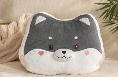 un coussin à l'effigie d'un chat posé sur un canapé