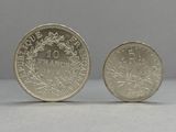 a close up of two coins on a table with a gray background