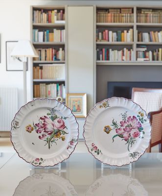deux assiettes posées sur une table devant une bibliothèque