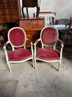 une paire de chaises rouges et blanches dans une pièce, avec une statue de cheval en arrière-plan