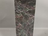 un vase en marbre posé sur une surface blanche