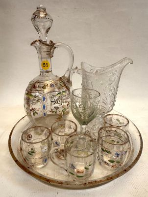 des bouteilles et des verres posés sur un plateau, avec une carafe et une carafe