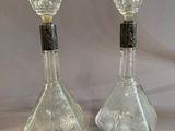 pair of clear glass decanters with black trims on a white background