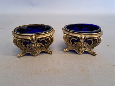 une paire de vases en verre bleu rehaussés de touches dorées, posés sur une table