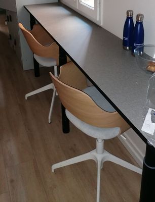 a long table with four chairs and a bottle of water on it