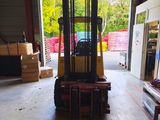 a forklift in a warehouse with a lot of boxes on the floor