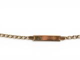 a close up of a gold chain bracelet with a small bar on it