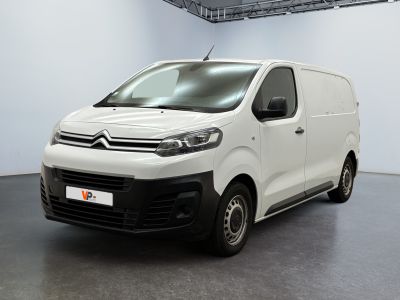 La camionnette blanche est garée dans la grande salle du bâtiment.