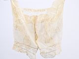 a white top hanging on a black hanger with a white background