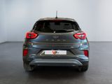 the rear end of a silver car in a white room