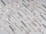de nombreuses fourchettes et cuillères disposées sur la table