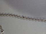 a silver chain with a heart on it on a table
