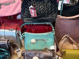 many purses on a table in a store