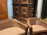 two wicker chairs and a couch in a living room
