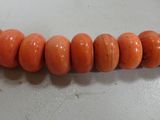 a close up of a strand of coral beads on a table