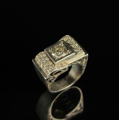 un gros plan d'une bague en argent sertie de diamants sur une surface noire