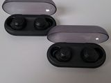 two black ear buds sitting on top of a table next to each other
